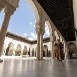 A woman walks through the grand mosque in paris, the largest mosque in paris.
